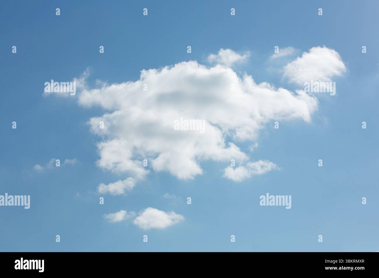 Single cumulus cloud is floating in flat design blue sky, with surrounding wispy clouds Stock Photo