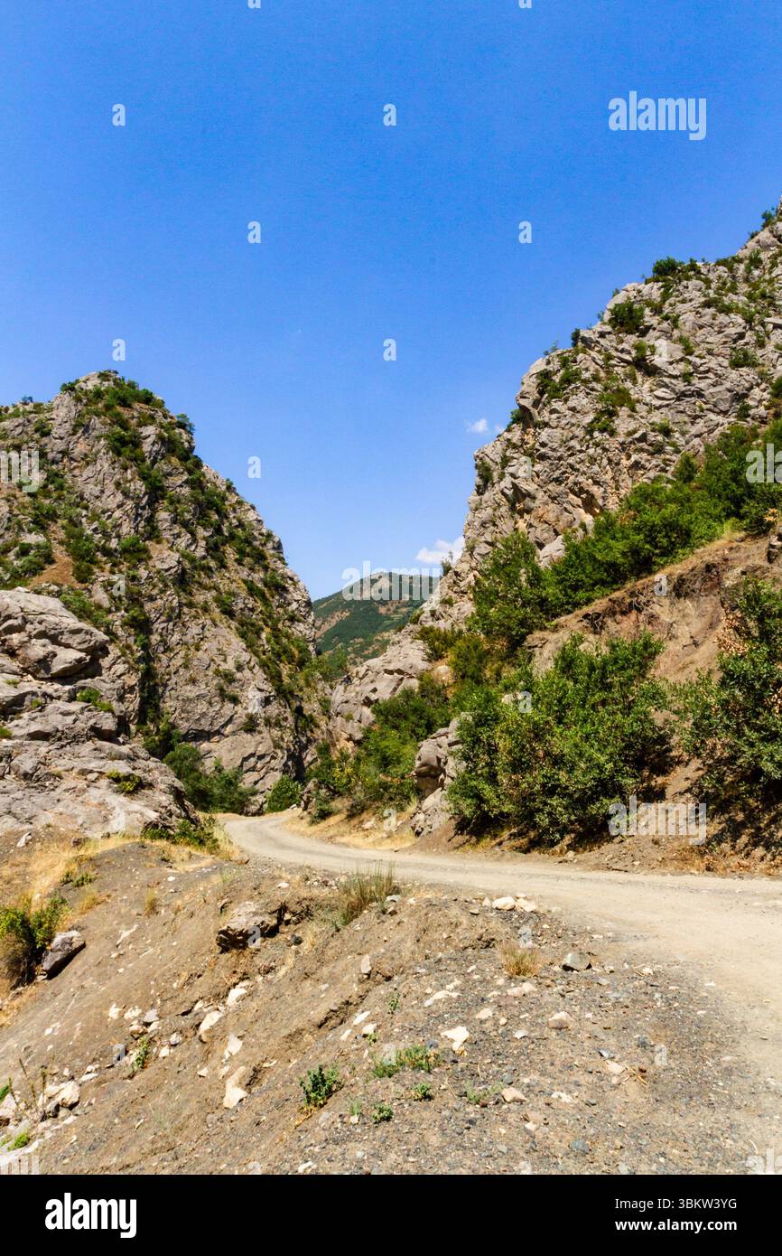 A dirt winding road between mountains. Albanian Alps, also known as the ...