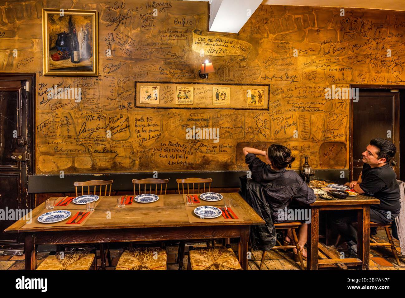 The rustic dining room at the Auberge-Restaurant Chez Cul de Paille in Poitiers has existed in its current form since 1843. Its walls are covered with numerous signatures of famous personalities, including French artists, singers and actors such as Arletty, Georges Brassens, Claude François, Jean Marais, Charles Aznavour, Yves Montand, Jaques Brel and Coluche. One of the special features of the Auberge Le Cul de Paille is that guests can choose their own table wine in the cellar and that many famous artists, such as Jaques Brel, have immortalised themselves on the walls with autographs, saying Stock Photo