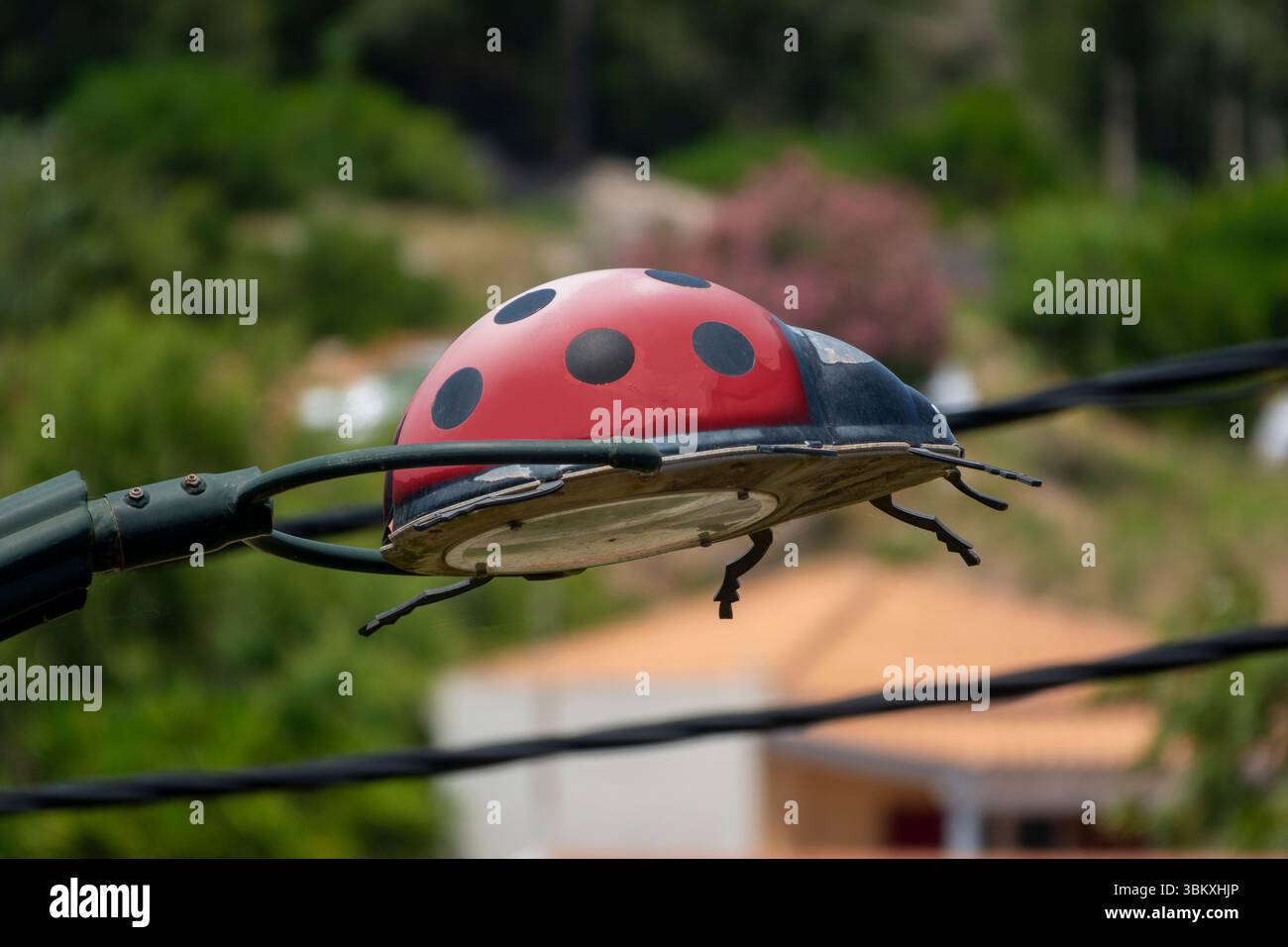 Novelty streetlight over a childrens' playground in the shape of a ladybird, Kefalonia, Greece Stock Photo
