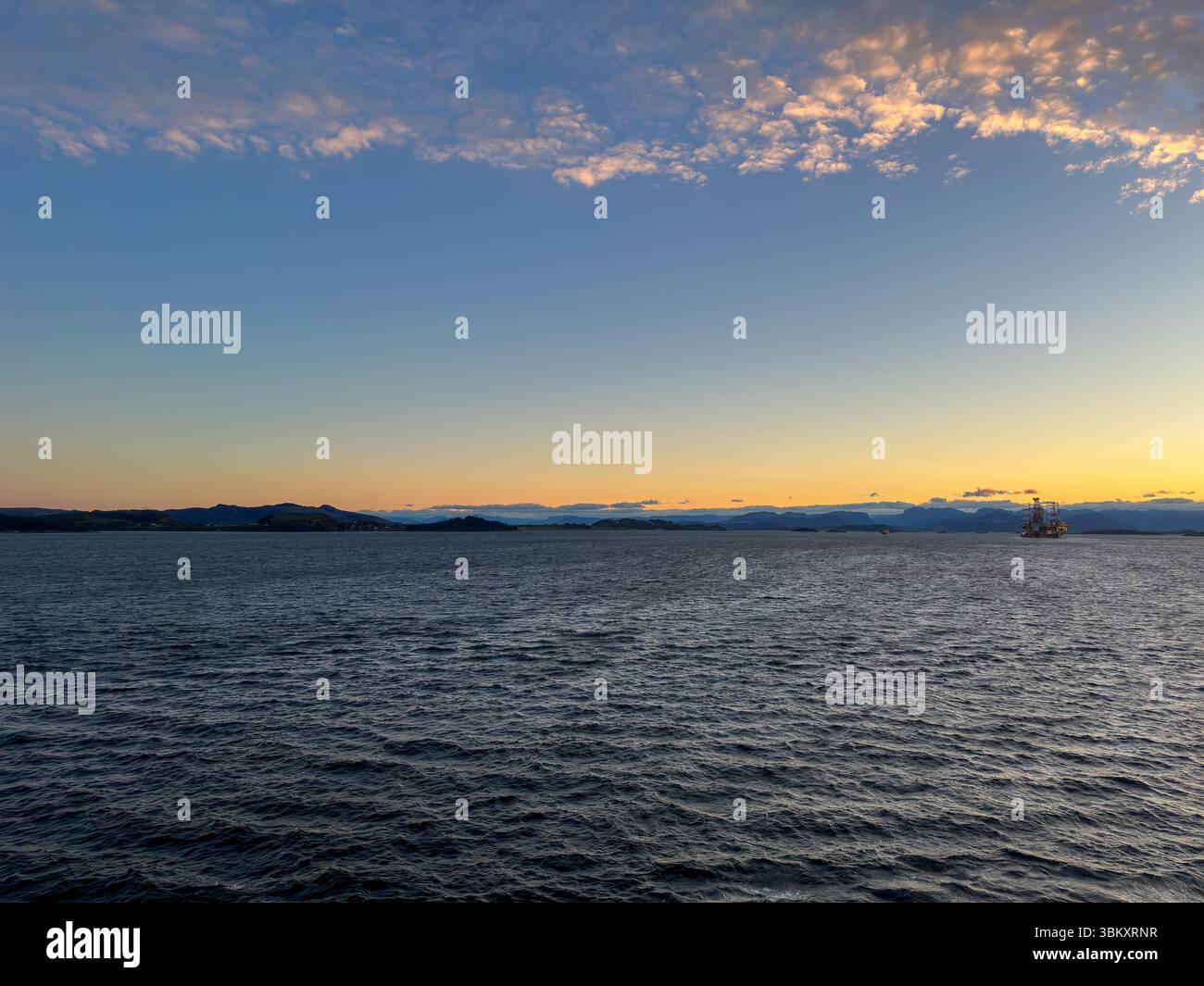 Norwegischer Industriehafen mit Werft, Kränen und rotem Frachtschiff bei Sonnenuntergang - Smartphone Captured Stock Image