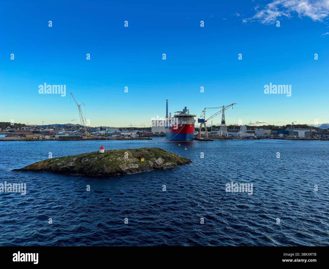 Norwegischer Industriehafen mit Werft, Kränen und rotem Frachtschiff bei Sonnenuntergang - Smartphone Captured Stock Image