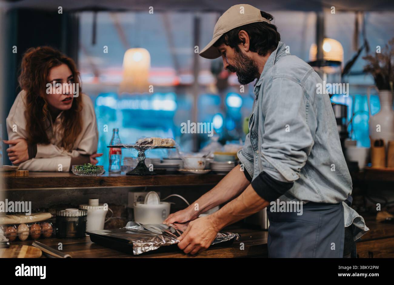 Two friends interacting at a cozy bar counter with warm lighting Stock ...