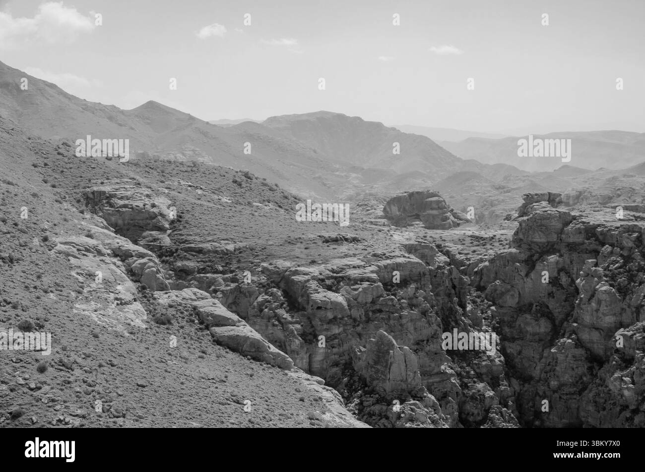 A rocky mountain range with a barren landscape. The sky is cloudy and the mountains are covered in rocks Stock Photo
