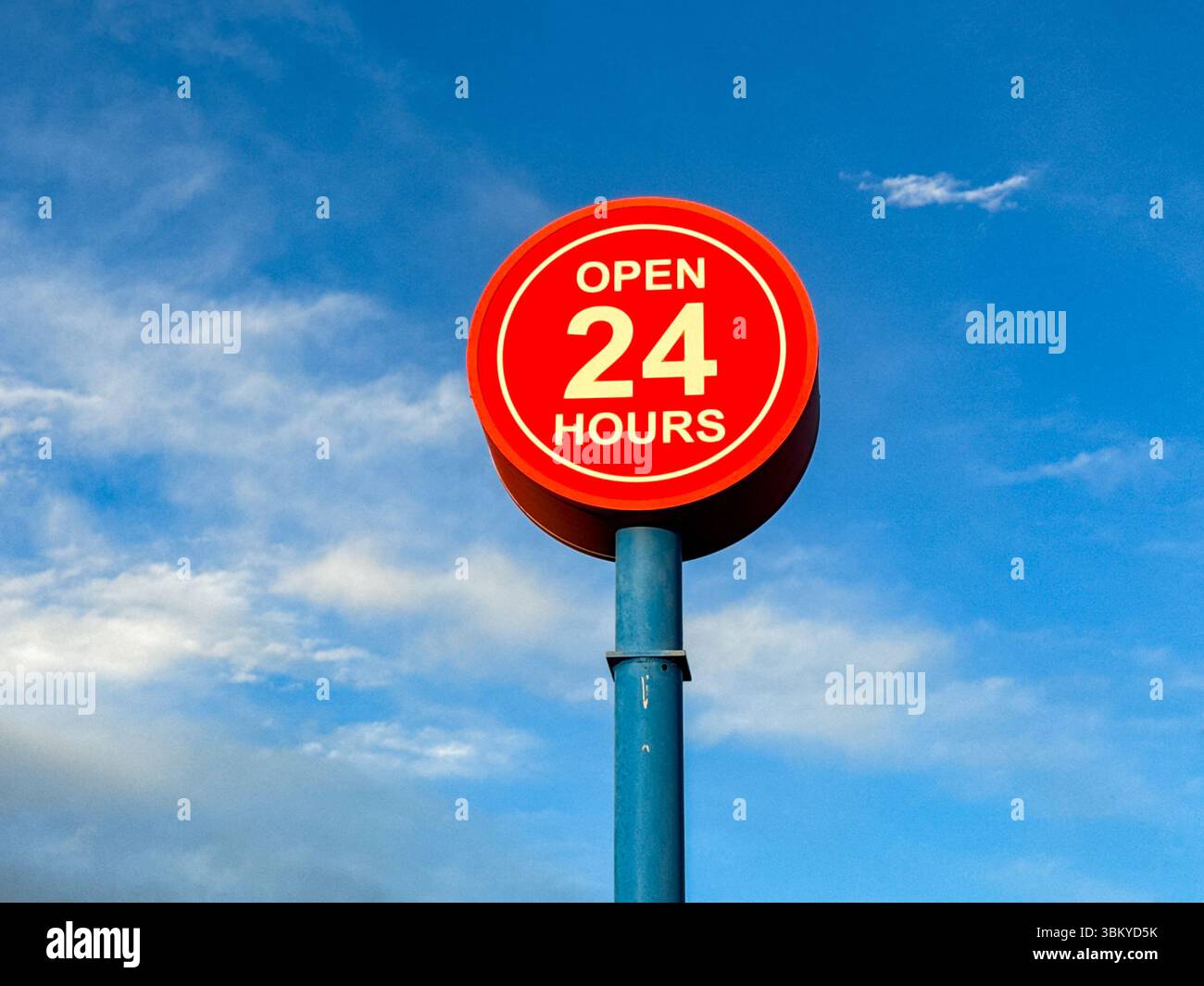 Open 24 hours sign isolated against a blue sky. No people. Copy space. - Smartphone Captured Stock Image