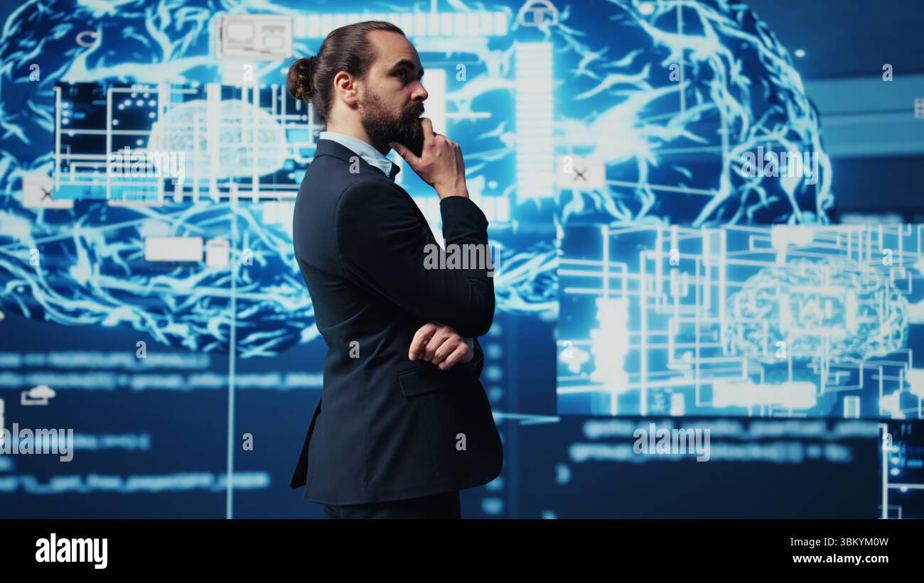 Young businessman reviews artificial intelligence neural networks on dashboard, using high tech automation tools for coding, analytics and deep learning for strategic development. Camera A. Stock Photo
