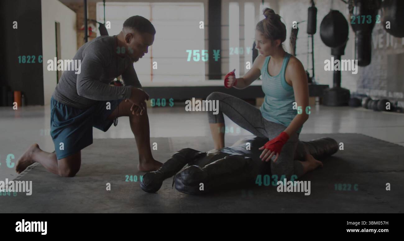 Training duo wearing athletic wear demonstrating grappling hold on mat at gym with grappling dummy Stock Photo
