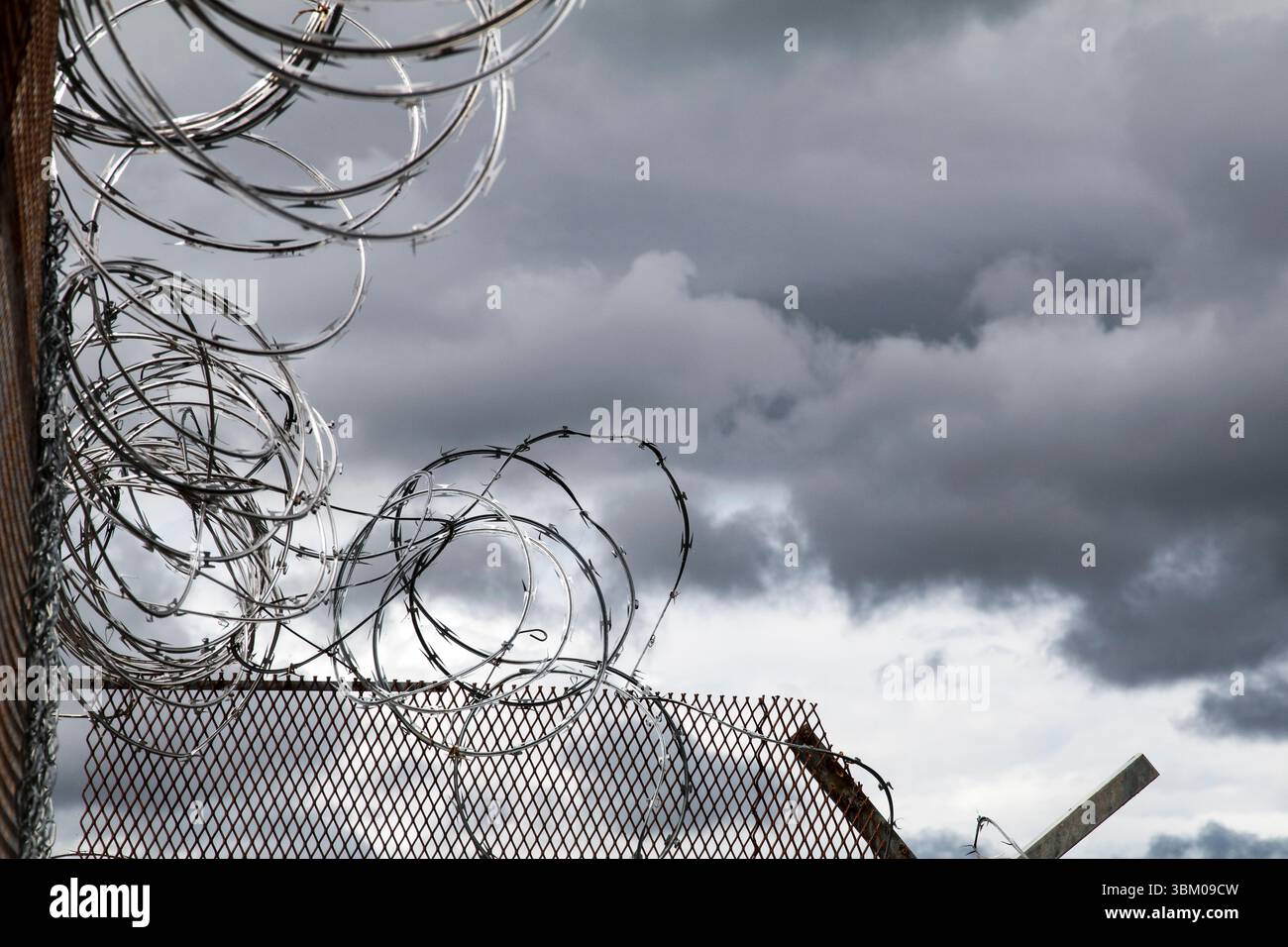 Barbed wire. Cloudy sky, dark storm clouds. Stock Photo