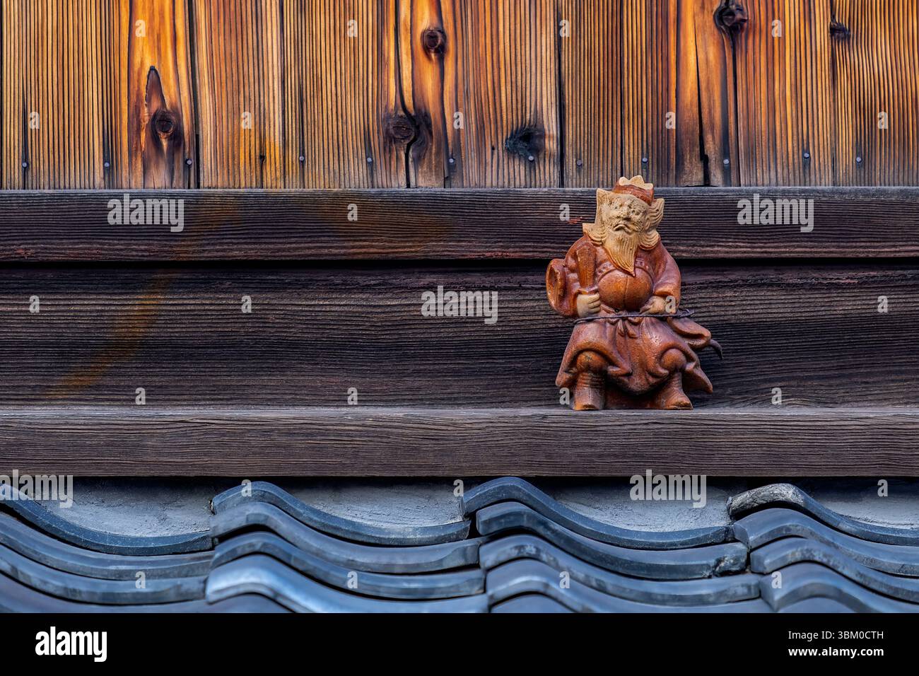 Figurine on rooftop eave of house, providing protection, Kyoto, Japan Stock Photo