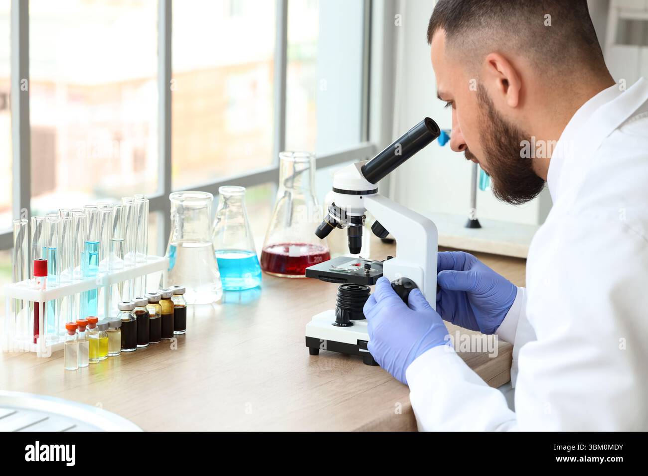 Male scientist looking through microscope in laboratory Stock Photo