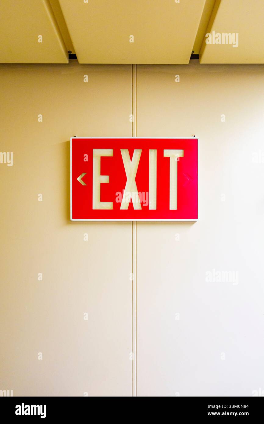 Red exit sign on wall, USA Stock Photo