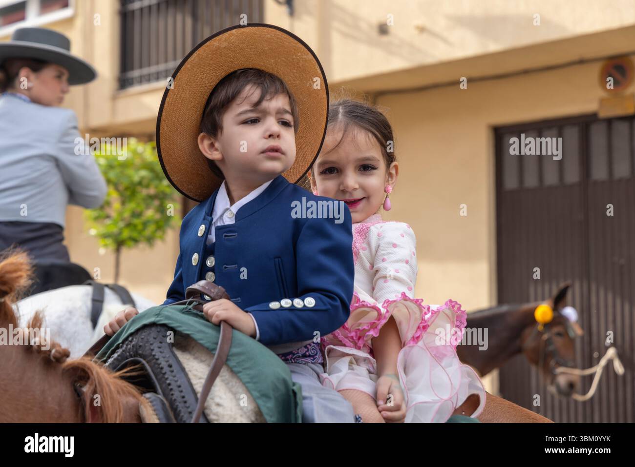 Andujar, Jaen Province, Andalusia, Spain. Girl and boy riding a horse for a procession during a religious festival. (Editorial Use Only) Stock Photo