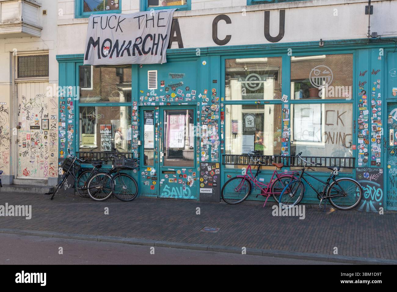 ACU building in Utrecht, Netherlands, displays a banner with strong anti-monarchy sentiment and numerous stickers covering its facade and doors. Utrec Stock Photo