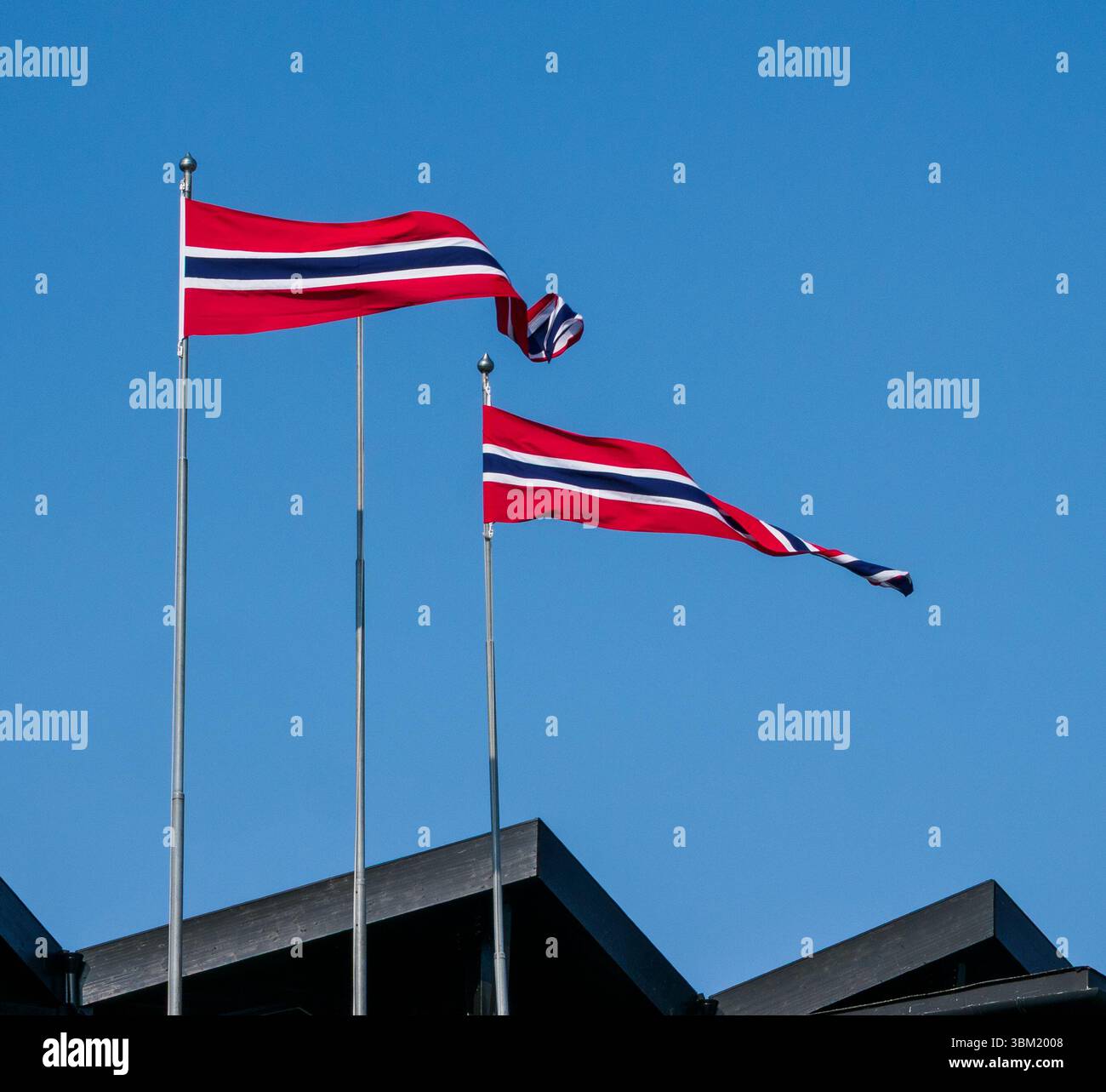 Pennants of the Norwegian flag flying over buildings in Beitostollen in the Jotunheimen National Park Norway Stock Photo