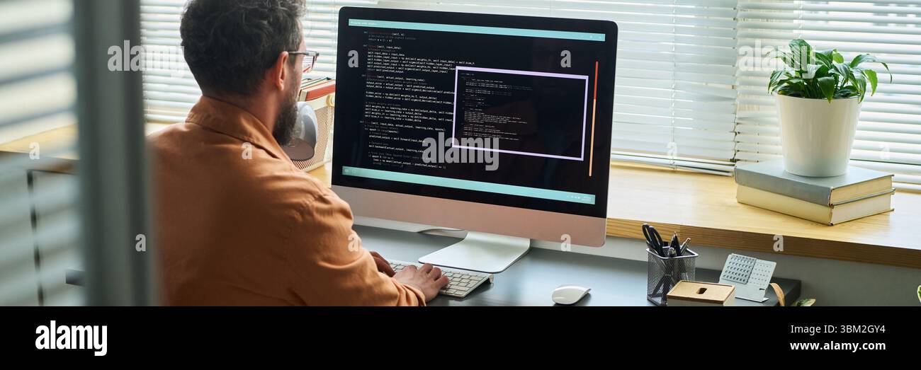 Caucasian Middle Aged Man Writing Neural Network Algorithms on Desktop Computer Stock Photo
