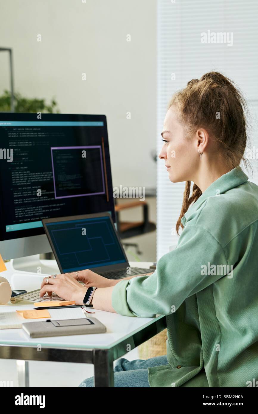 Woman Writing Neural Network Algorithms on Desktop Computer Stock Photo