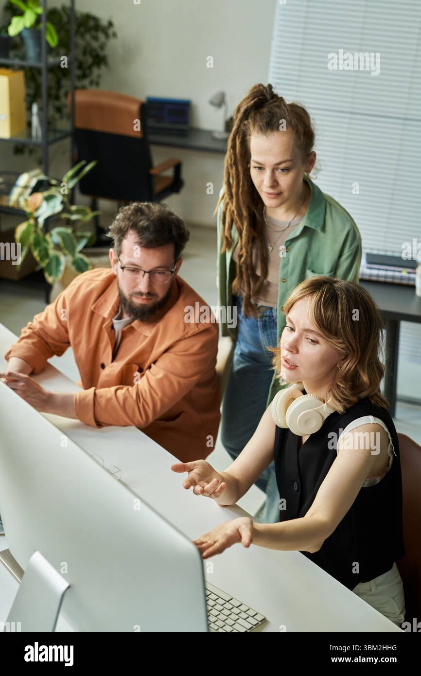 Young Adult Multiethnic Team Analyzing Neural Network Data on Desktop Computer Stock Photo