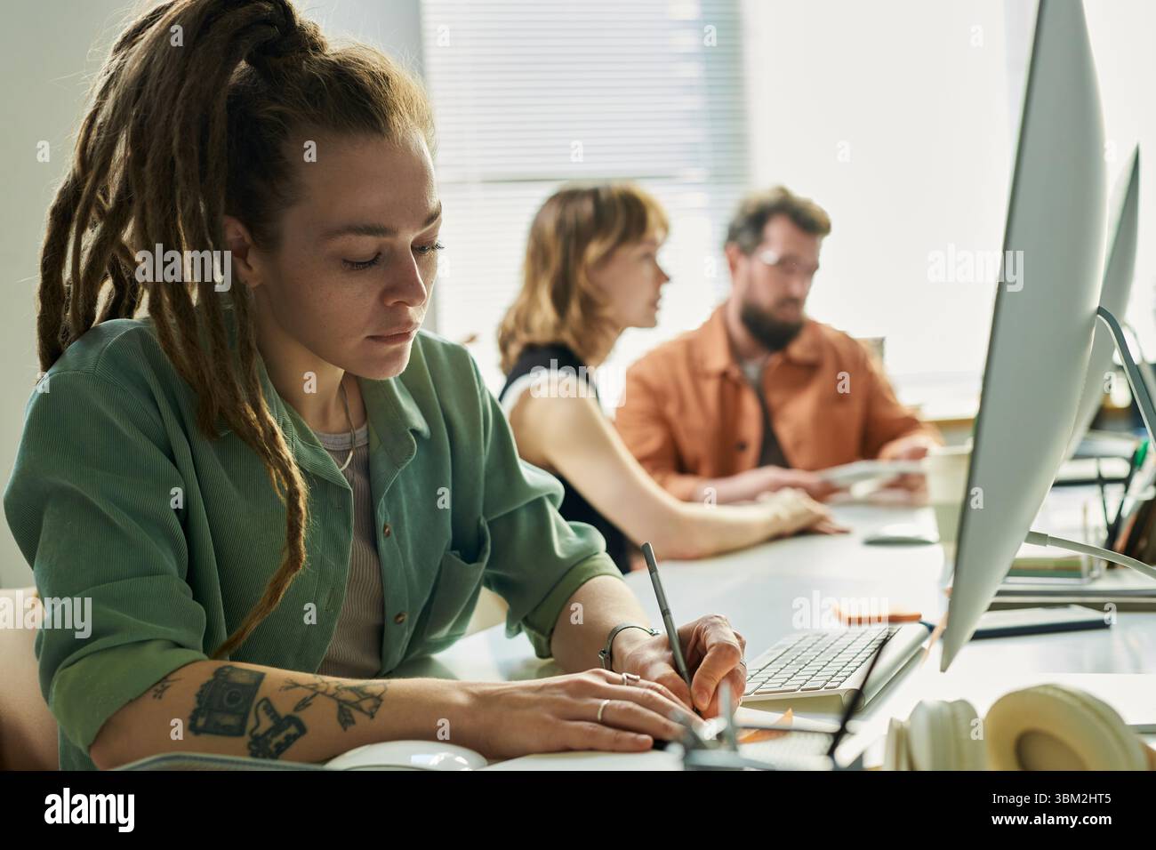 Young Caucasian Woman Developing Neural Network at Computer in Office Setting Stock Photo