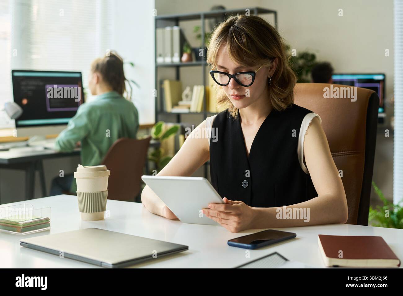Young Caucasian Woman Developing Neural Network Using Digital Tablet in Office Stock Photo