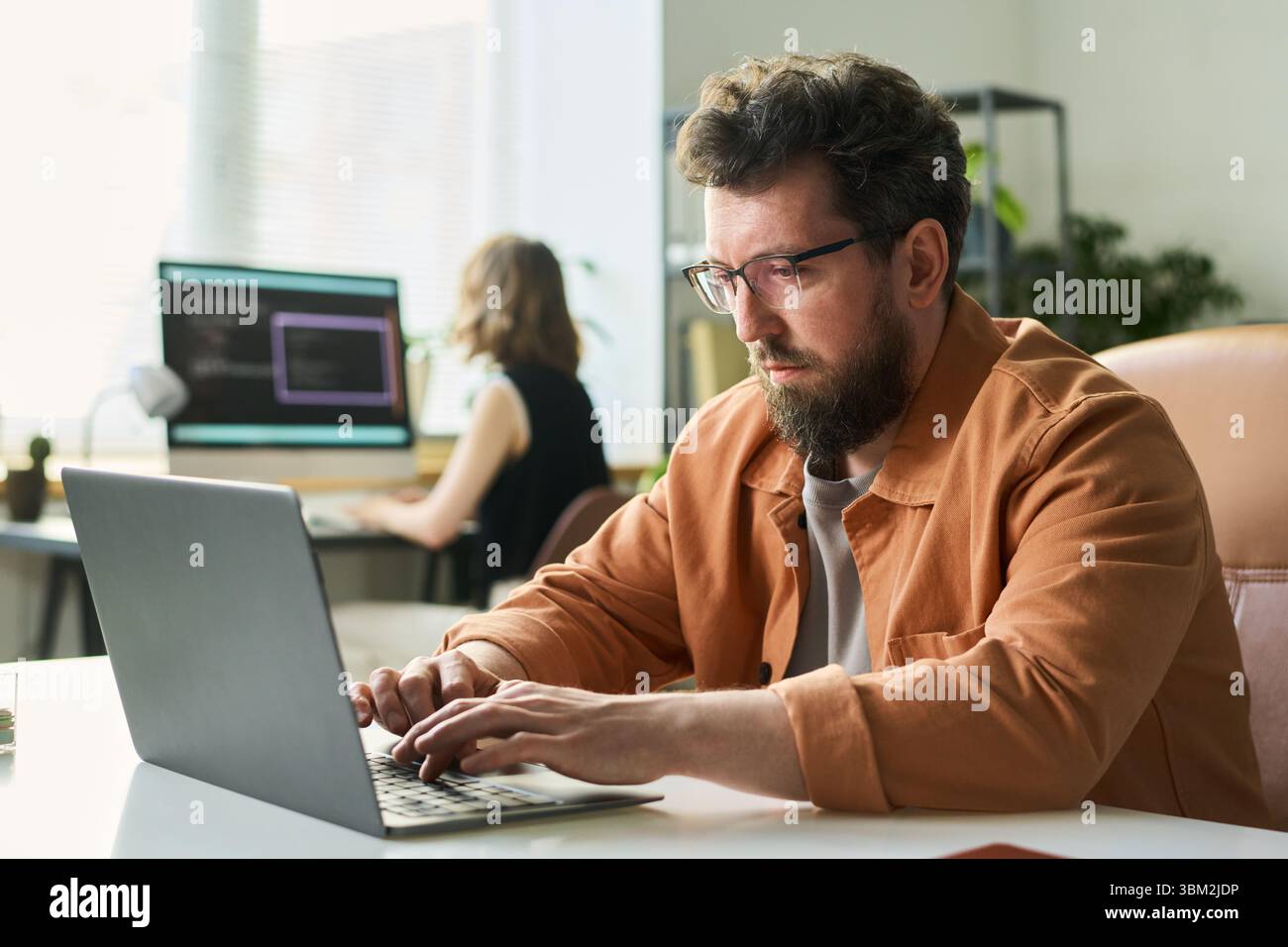 Man Developing Neural Network on Laptop in Office Stock Photo