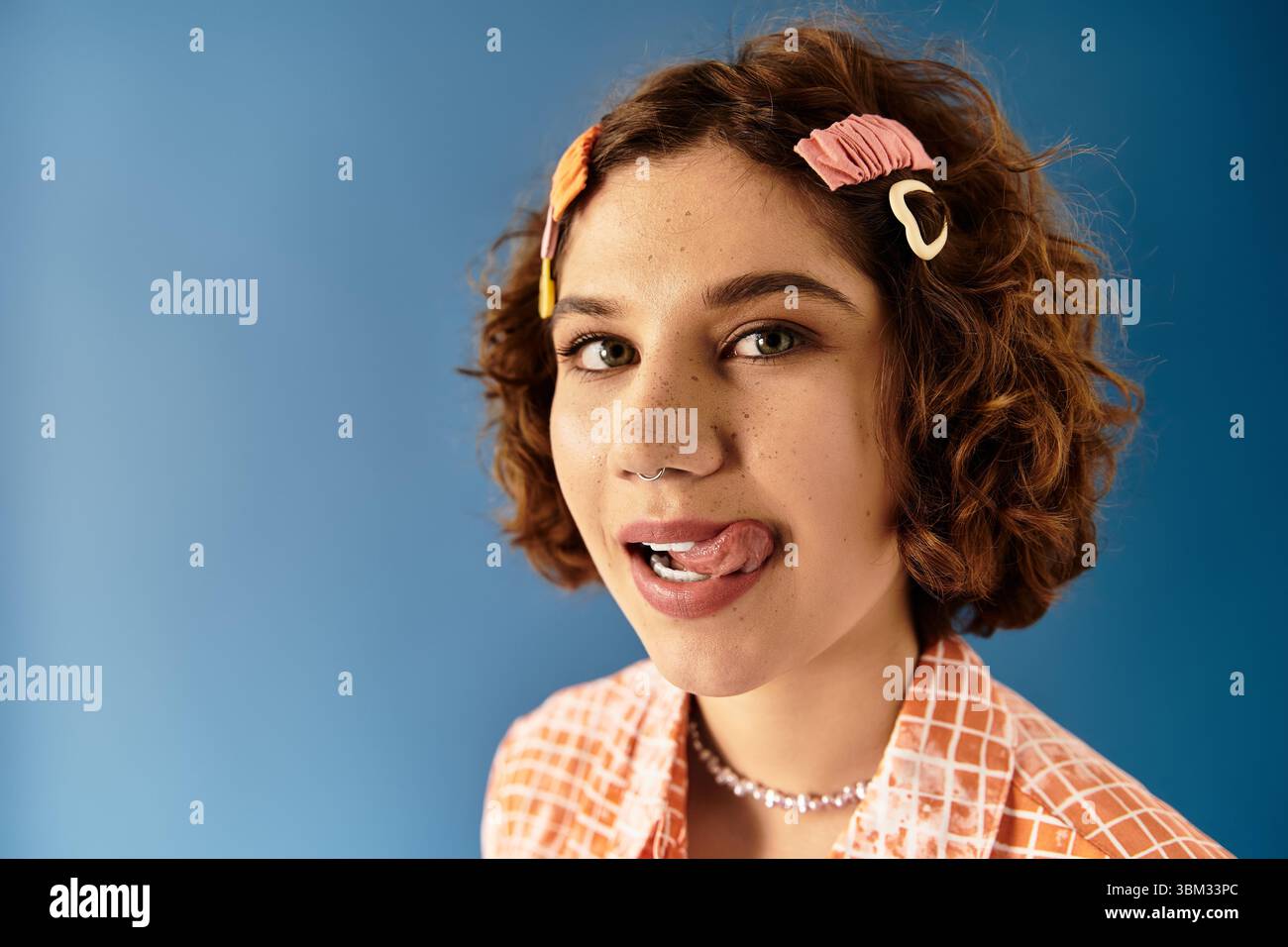 A young woman with curly hair confidently poses in a colorful outfit ...