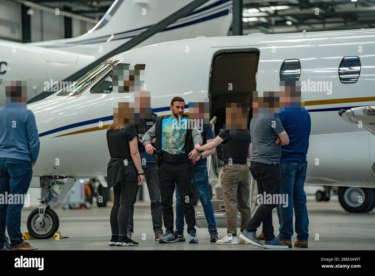 EDITORS NOTE: Image blurred at source. Undated handout photo issued by the Metropolitan Police of James Harding being arrested by officers from the Metropolitan Police following his extradition from Switzerland. A pair of drug kingpins are facing jail for plotting to murder a rival and smuggling millions of pounds worth of cocaine into the UK following one of the largest EncroChat investigations in history. James Harding, 34, and his "loyal right-hand man" Jayes Kharouti, 39, ran a vast criminal empire which made £5 million in profits from importing drugs over 10 weeks in 2020 alone. Issue dat Stock Photo