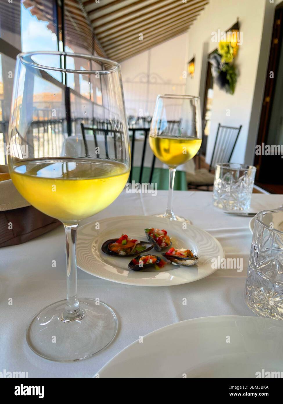 Two glasses of white wine with mussels as tapa. Spain. - Smartphone Captured Stock Image