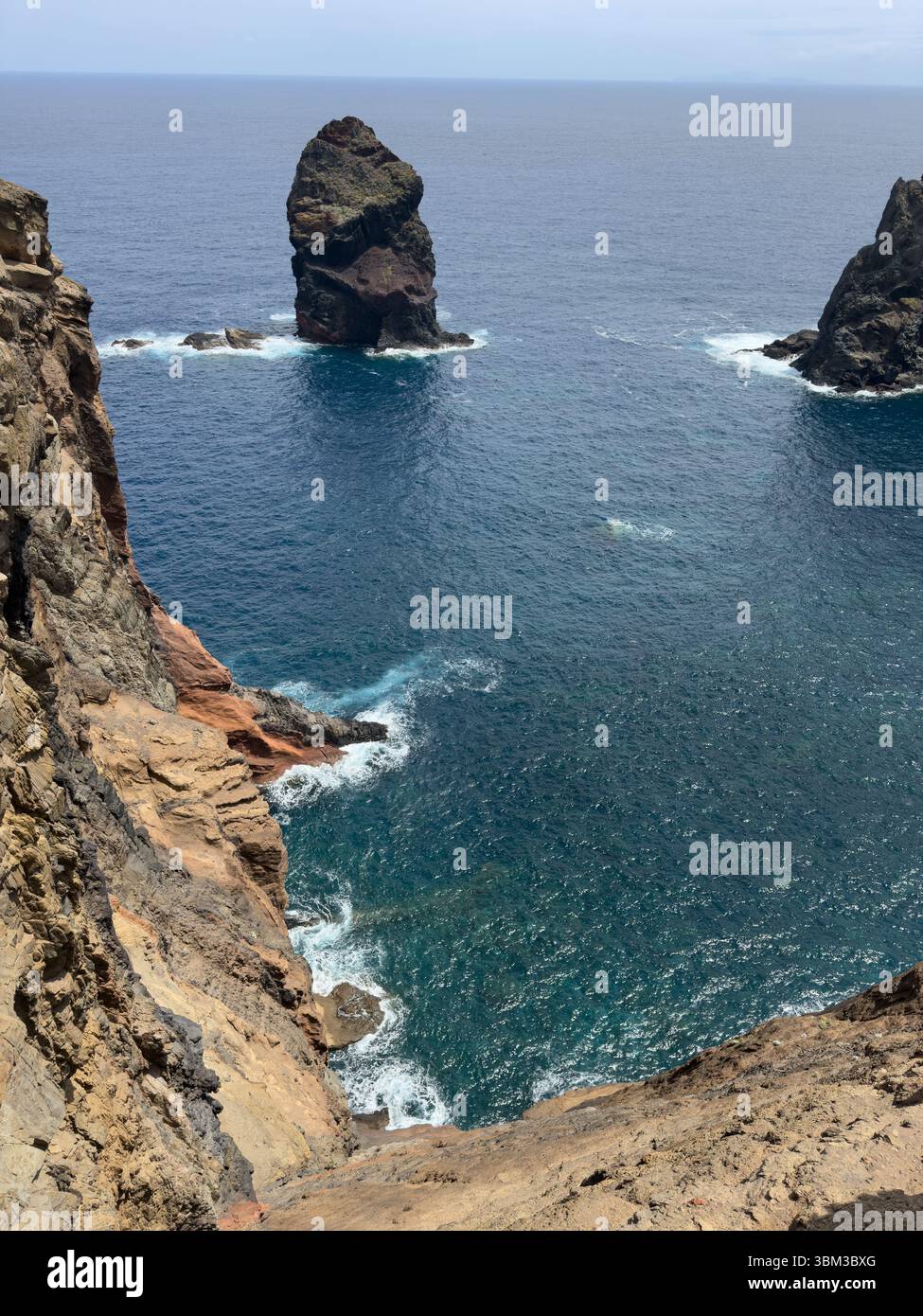 Ocean waves crashing against huge rocky mountains on coast of Madeira, Portugal. Seascape with white surf, sea spray and rocks. - Smartphone Captured Stock Image
