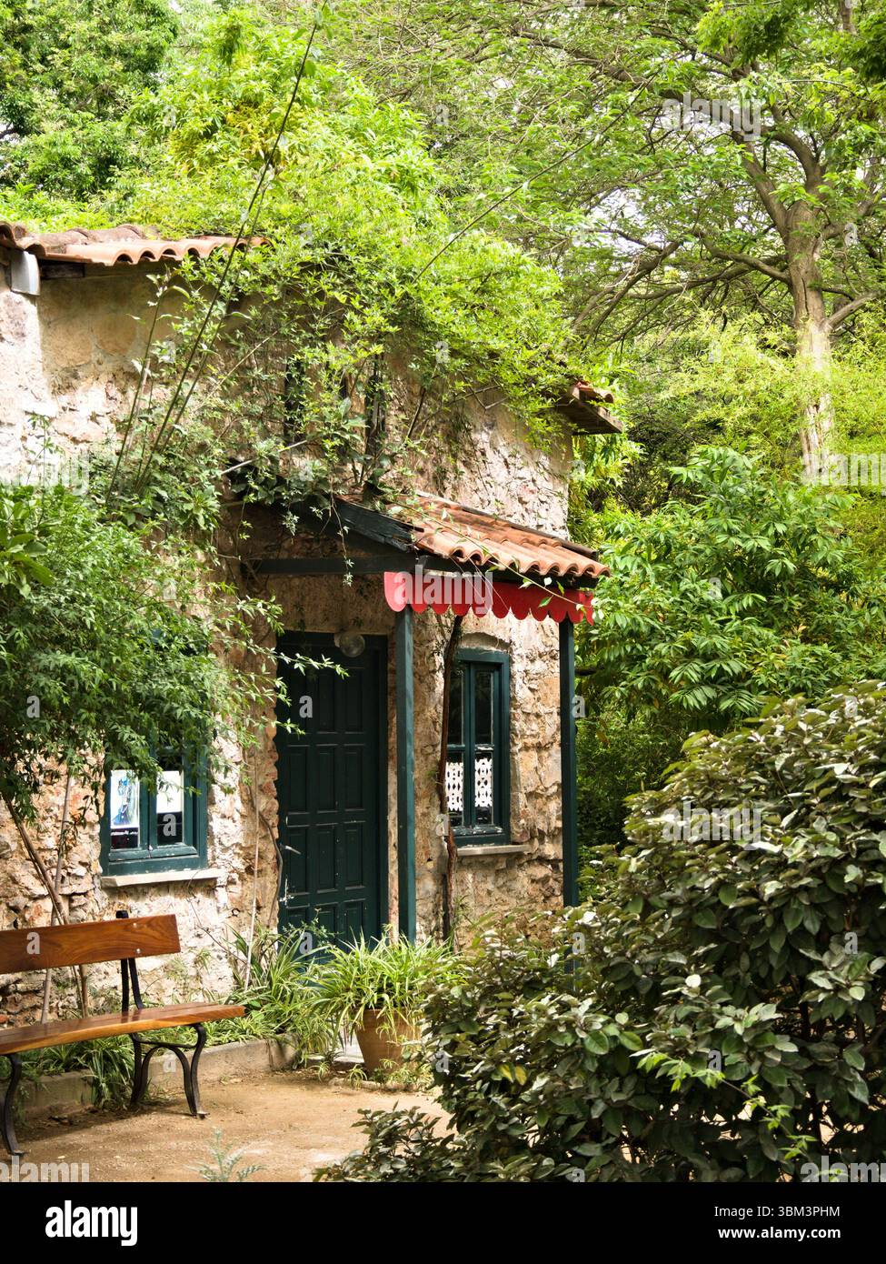 Rustic stone house with green shutters and wooden bench surrounded by ...