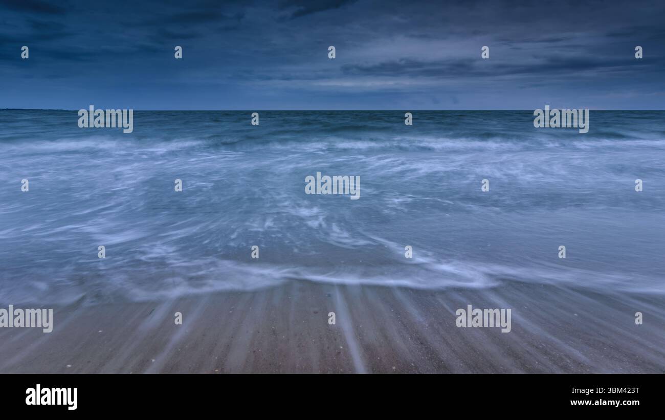 Dynamic Ocean Waves Under a Moody Blue Sky. Stock Photo