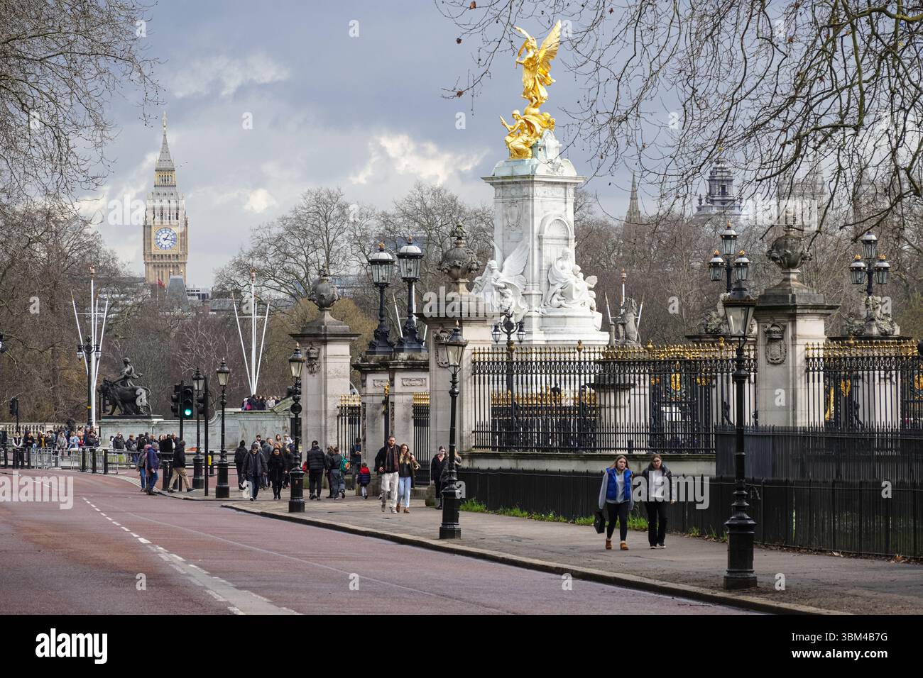 Tourists on Constitution Hill in Green Park, next to Queen Victoria Memorial and the Buckingham Palace in London England United Kingdom UK Stock Photo