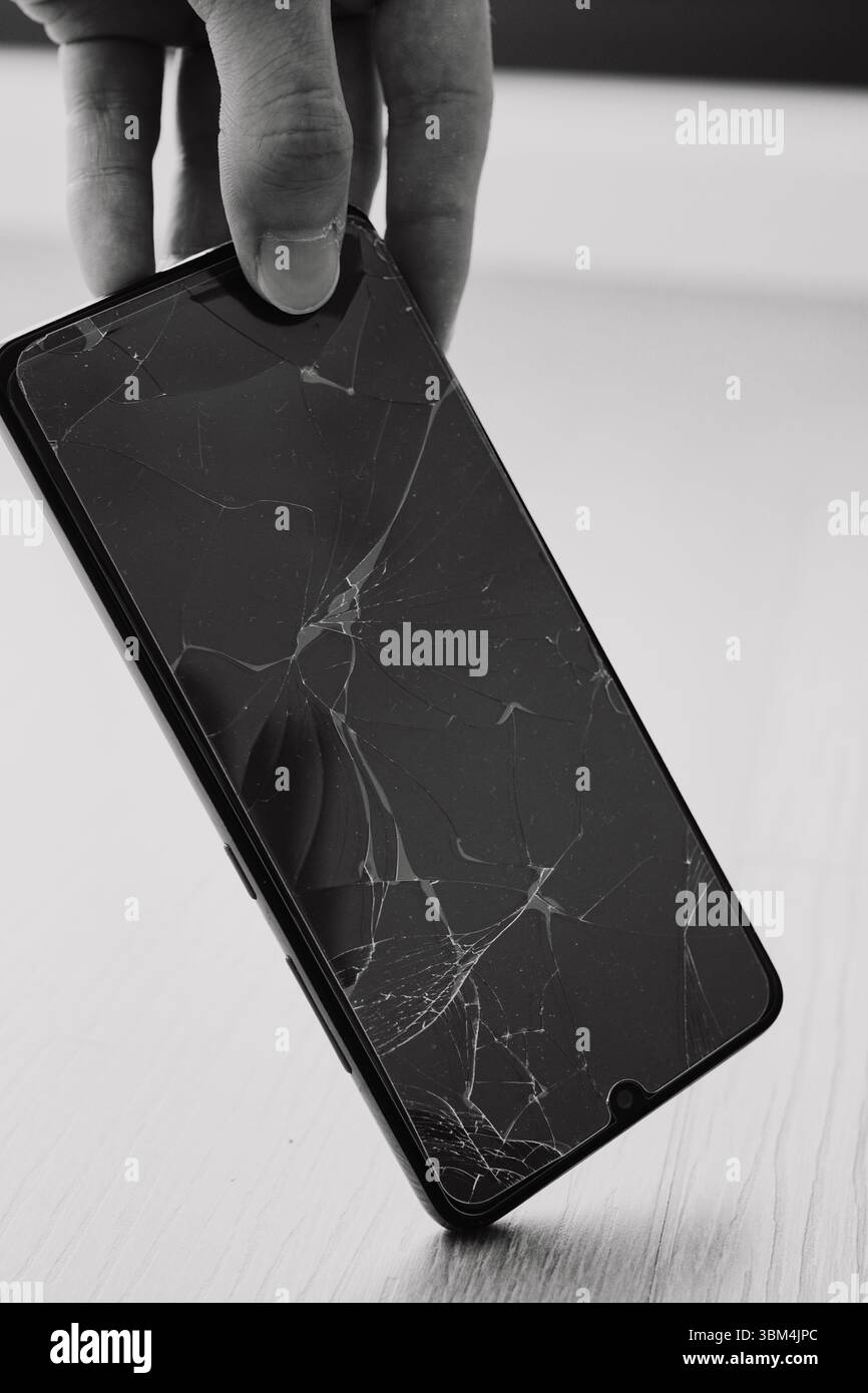 Broken cell phone screen after falling on the floor Stock Photo