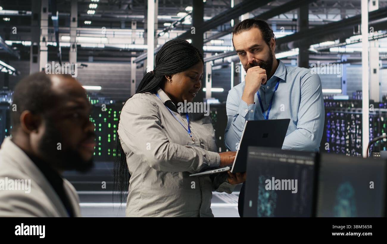 Data center engineers performing maintenance on blade server units used for artificial intelligence processing. IT professionals manage data center arrays used for machine learning training, camera A Stock Photo