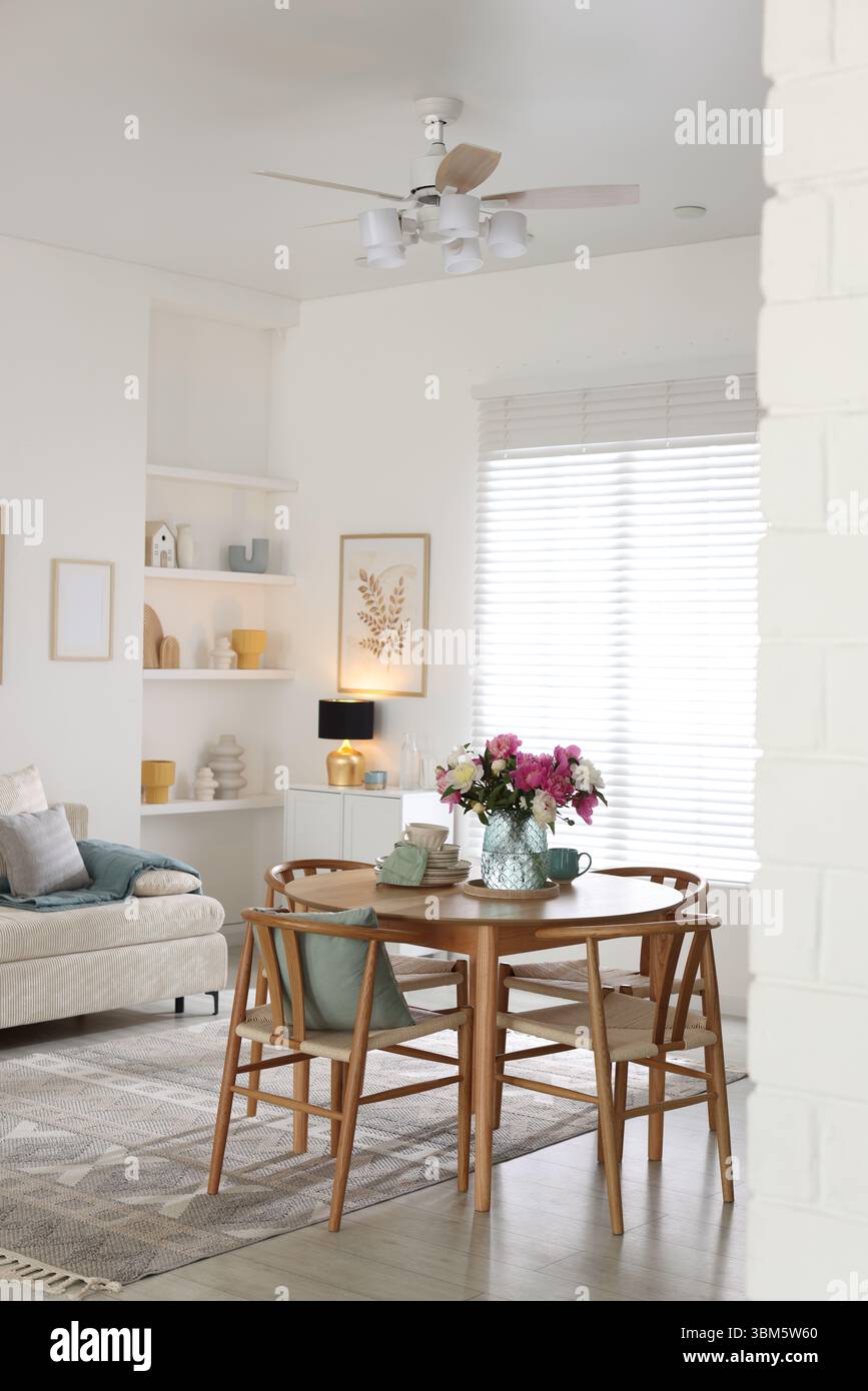 Dining table with beautiful flowers and dishware in room, space for ...
