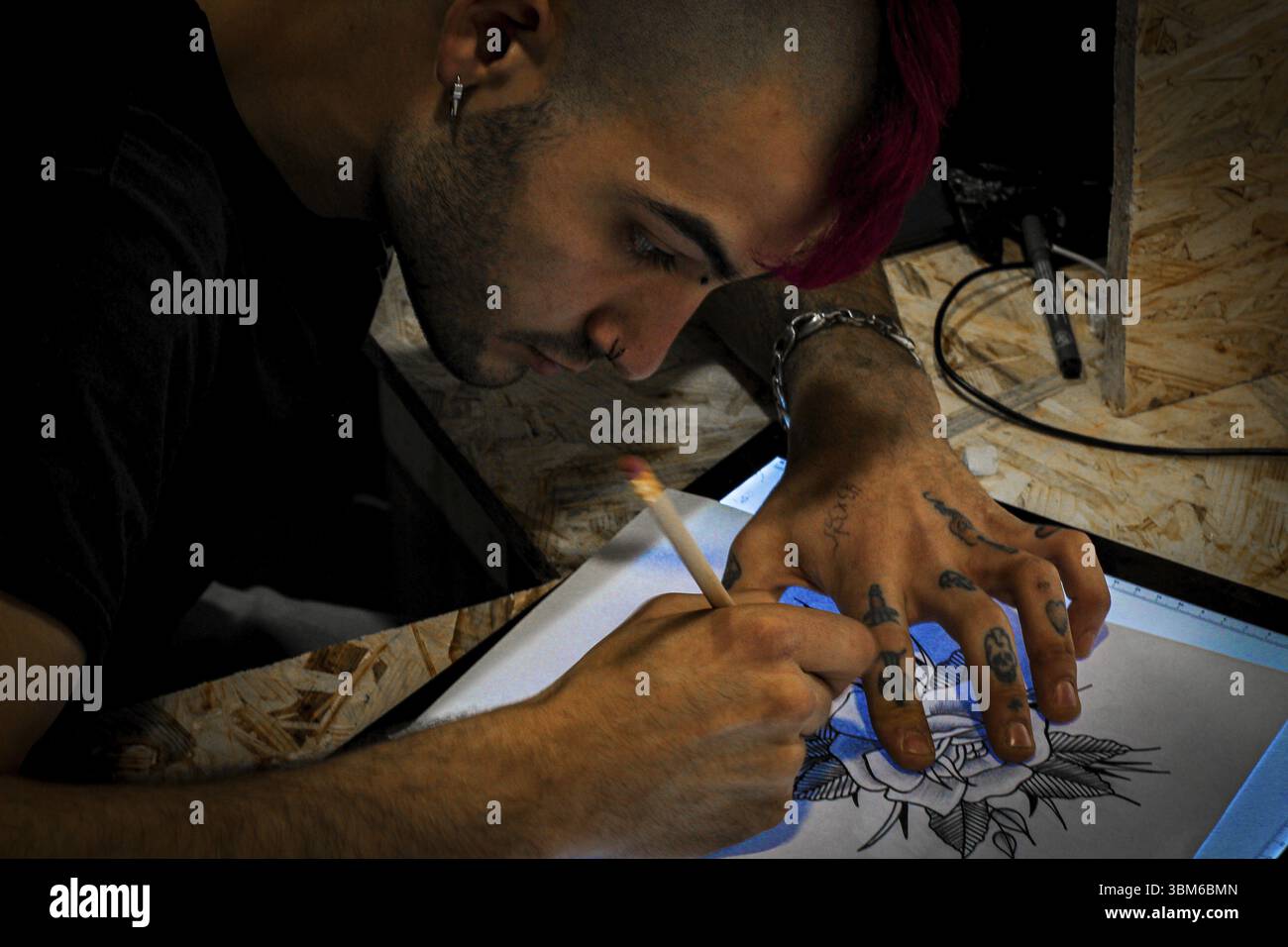 Tattooist designing a tattoo drawing on paper on a digital drawing