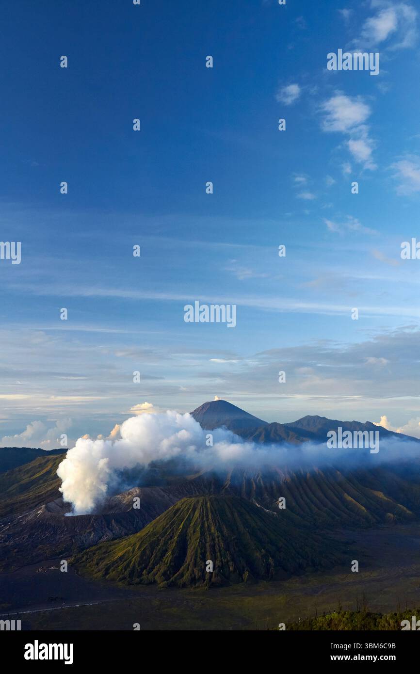 Smoke and steam coming from Mt Bromo (Gunung Bromo) with Mt Semeru in distance, East Java, Indonesia Stock Photo