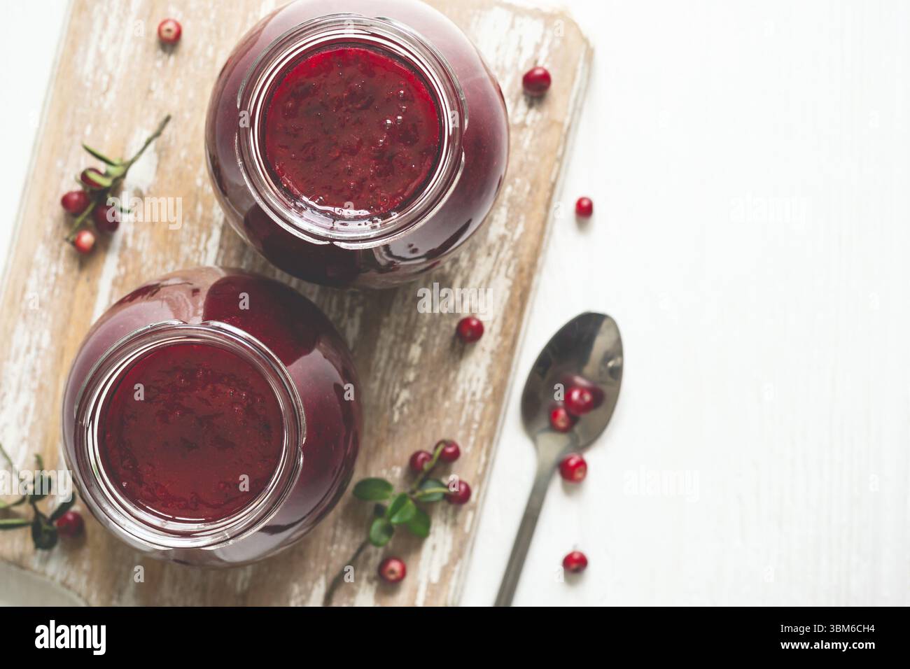 Lingonberry jam in jars and fresh berries. Selective focus, copy space Stock Photo