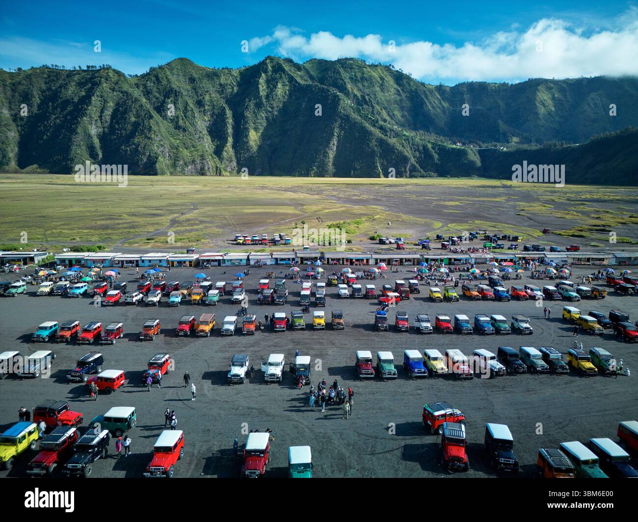 Old Toyota Landcruisers for transporting tourists, on Segara Wedi (sand ocean) below Mt Bromo Volcano (Gunung Bromo) East Java, Indonesia - aerial Stock Photo