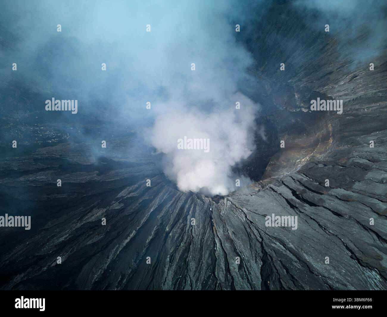 Looking into the rumbling crater of Mt Bromo Volcano (Gunung Bromo) East Java, Indonesia - aerial Stock Photo