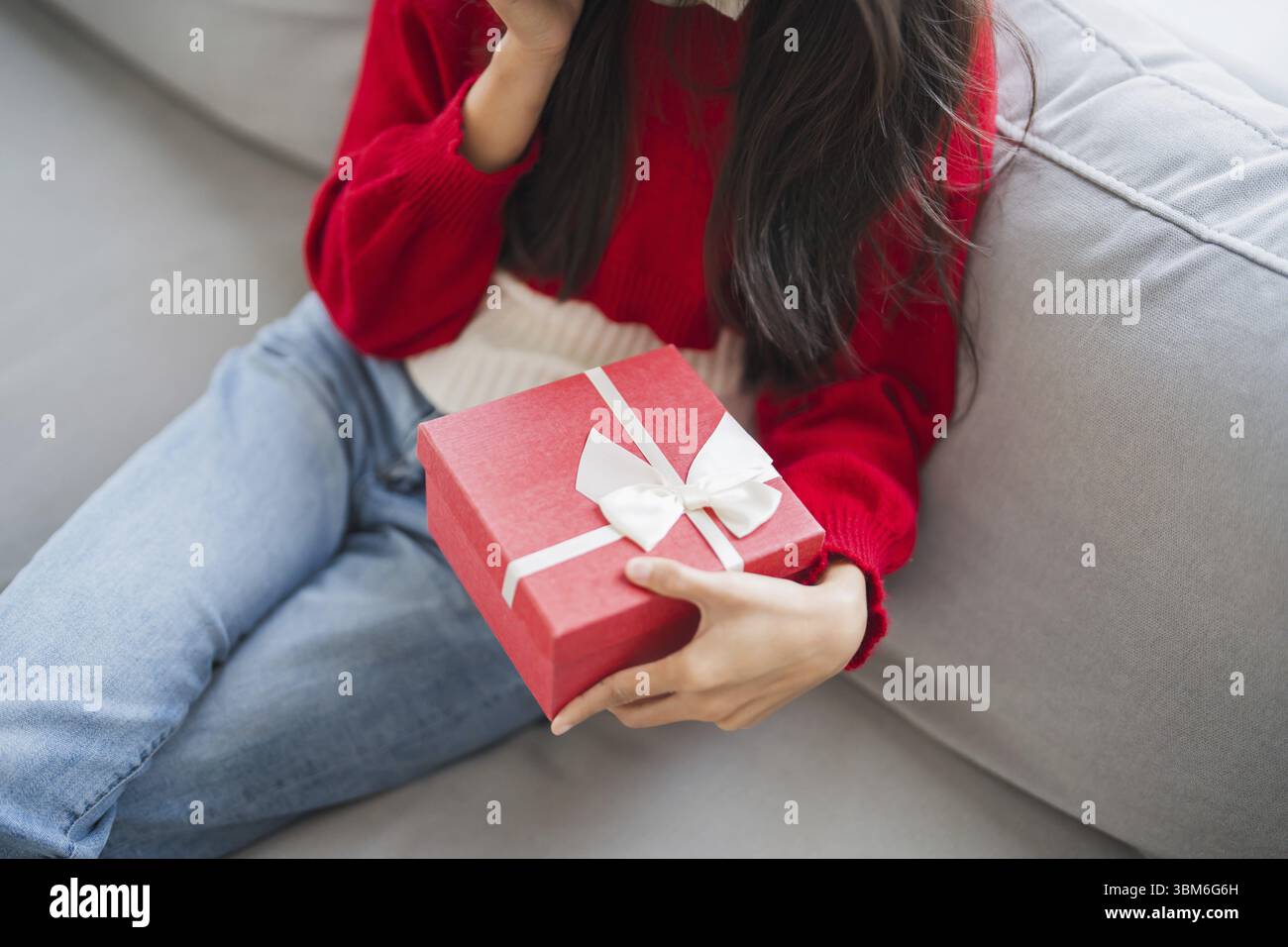 Receiving Valentine present. Cheerful girl asian holding gift box Stock Photo