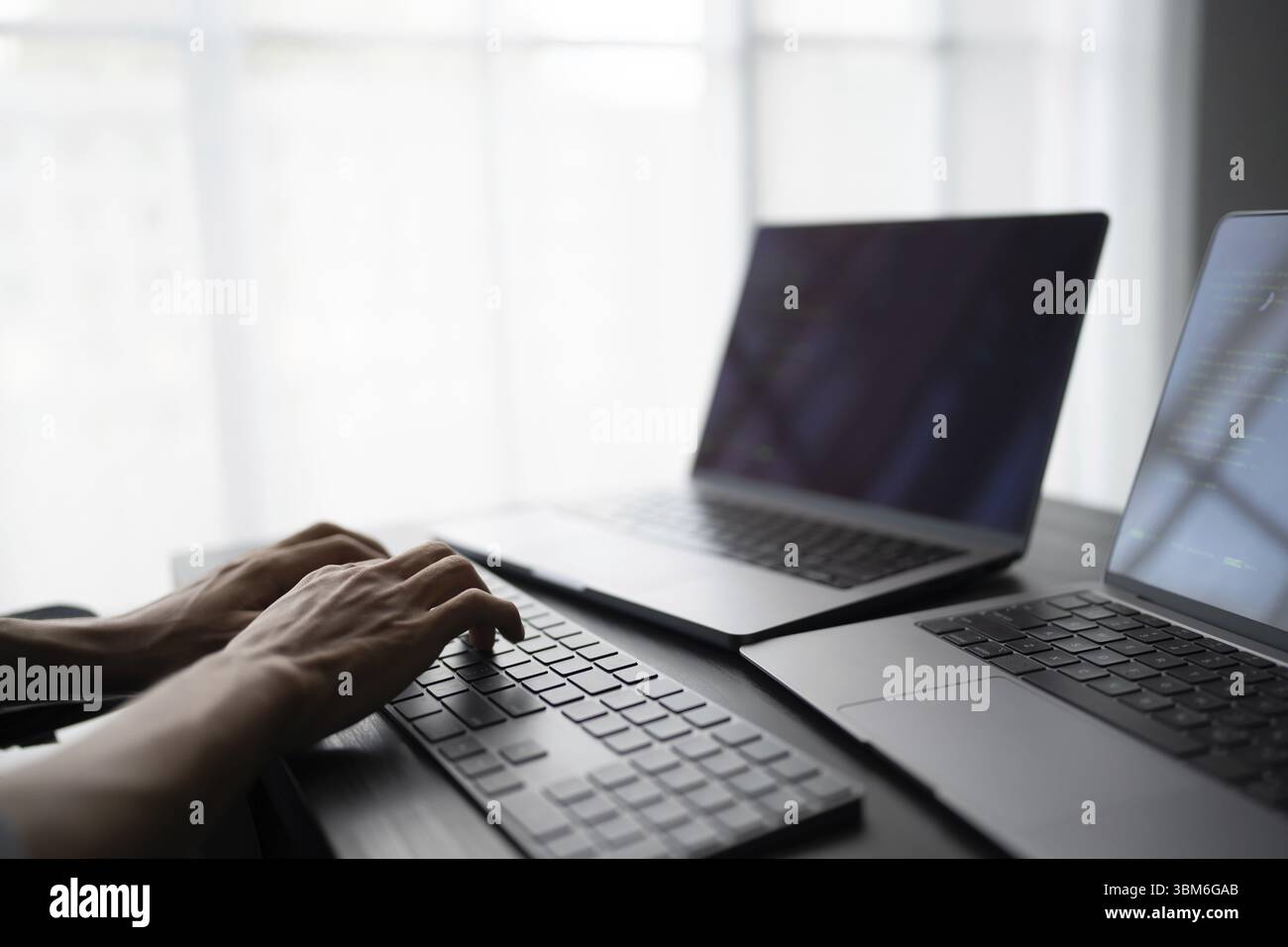 Asian man software engineer Working on Computer at office desk for writing program code IT Software Engineer finding errors tech support devops creati Stock Photo