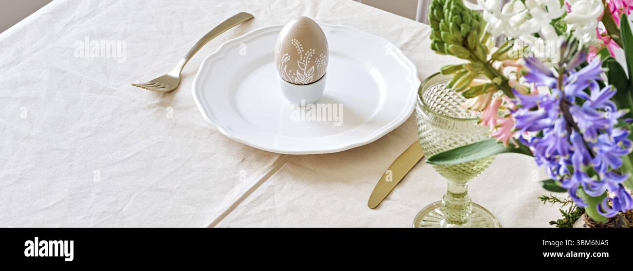 Easter table setting banner with natural Hyacinths flowers. Selective focus, home festive atmosphere Stock Photo