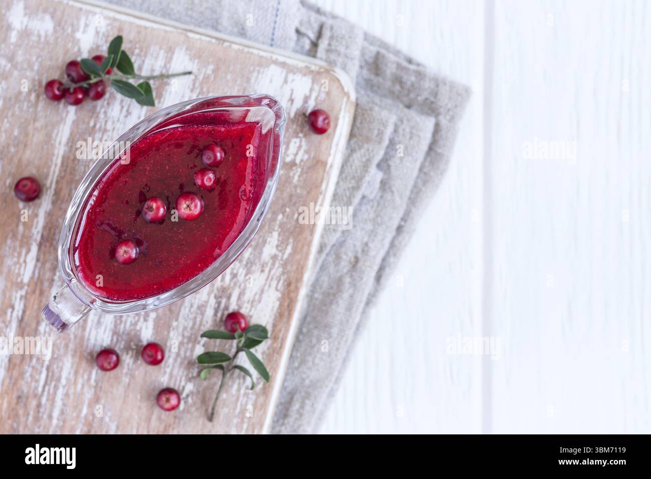 Fresh Lingonberry sauce in a gravy boat. Top view with copy space Stock Photo