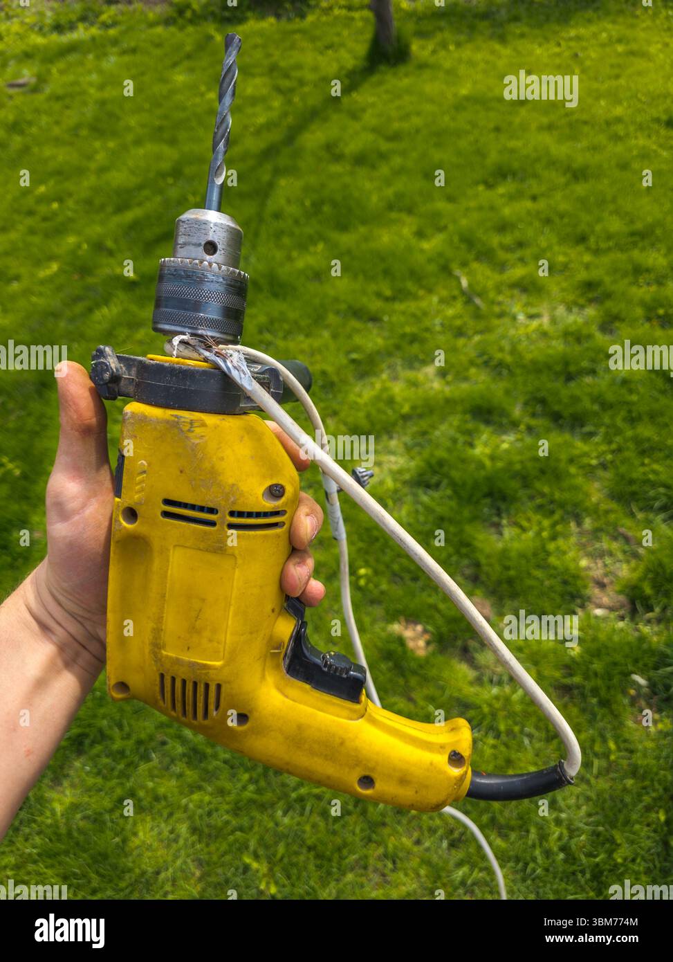 Adult man holding drill with damaged power cord outdoors Stock Photo ...
