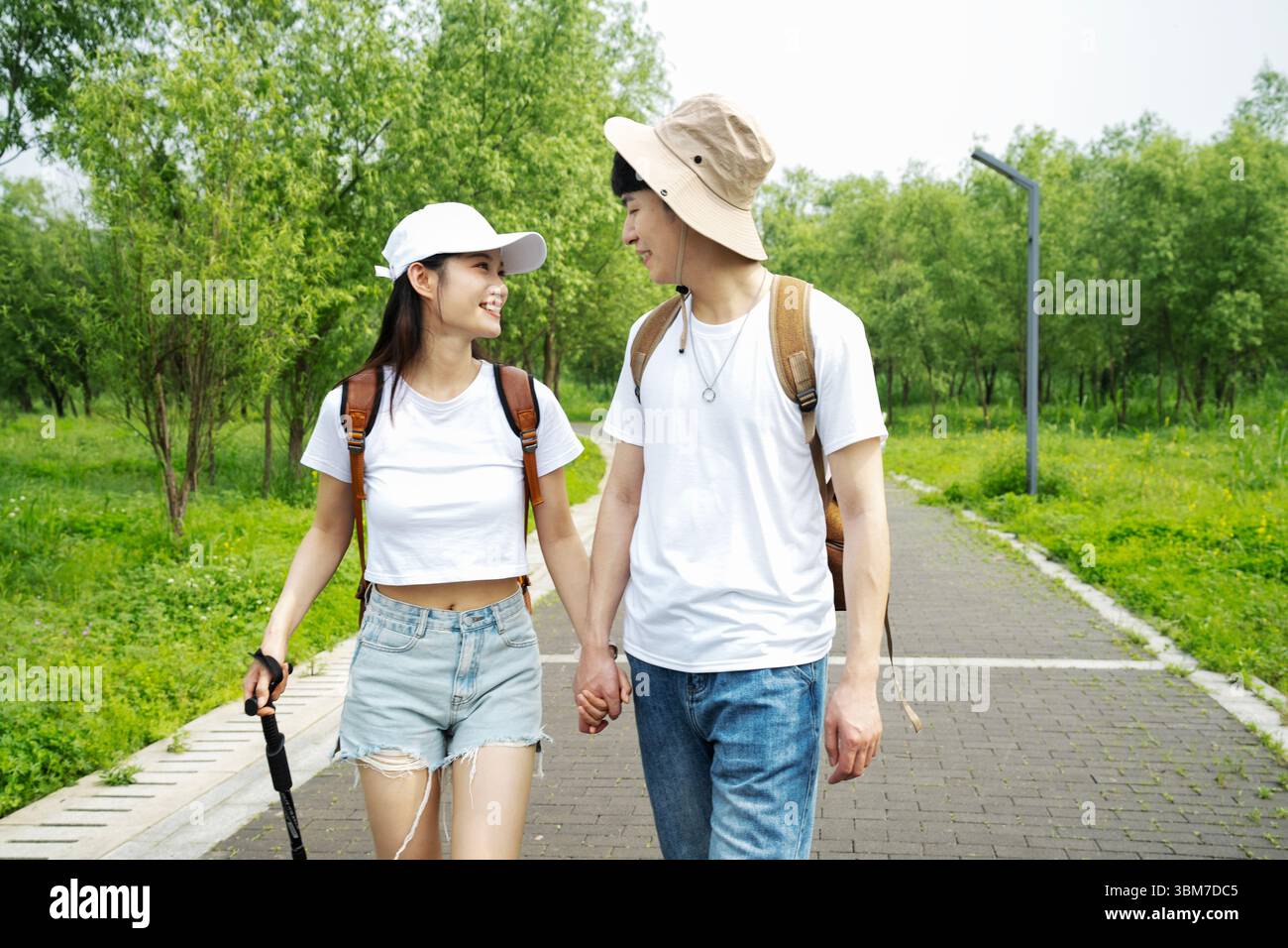 A young couple walking hand in hand through the forest Stock Photo - Alamy