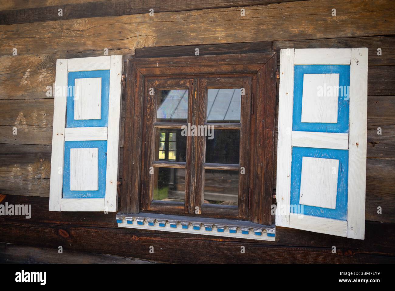 A window with blue and white shutters is open, letting in some light ...