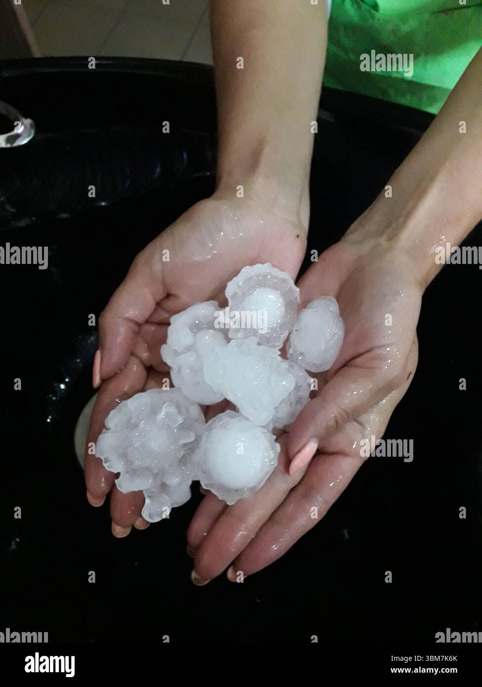 Large ice hail in female hands Stock Photo - Alamy