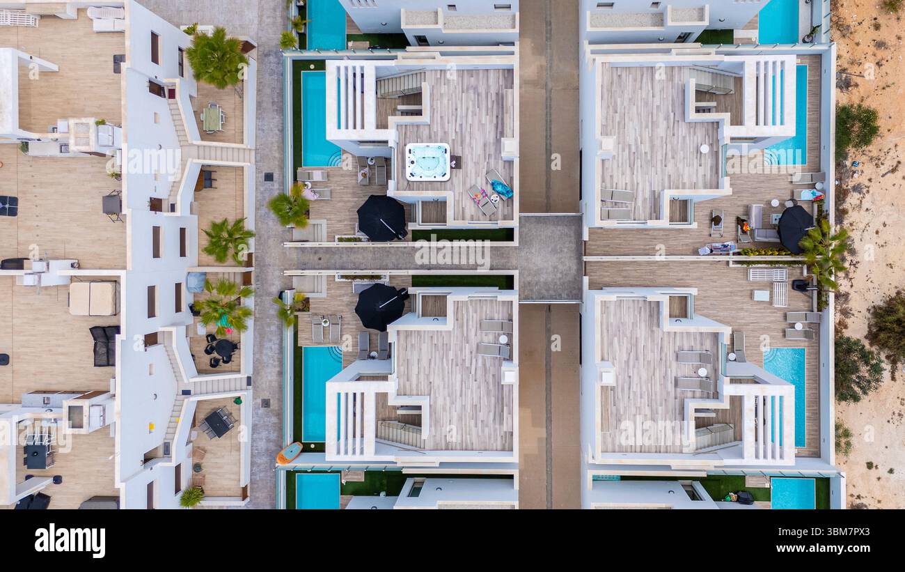 Aerial layout of white villas featuring private pools, jacuzzi, terraces and organized modern design. Stock Photo