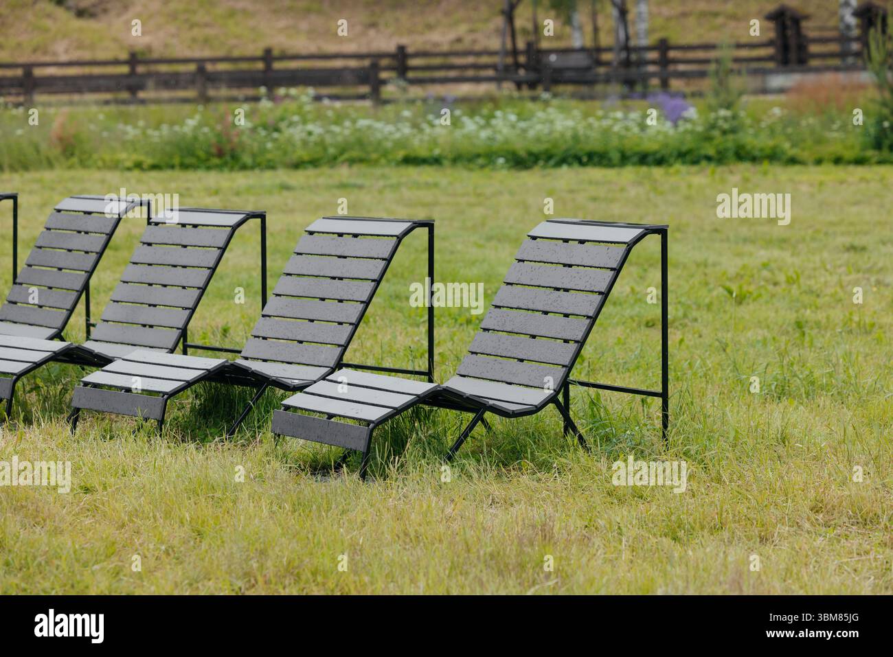 Modern urban bench lounger made of wood and black metal for public parks and city spaces Stock Photo