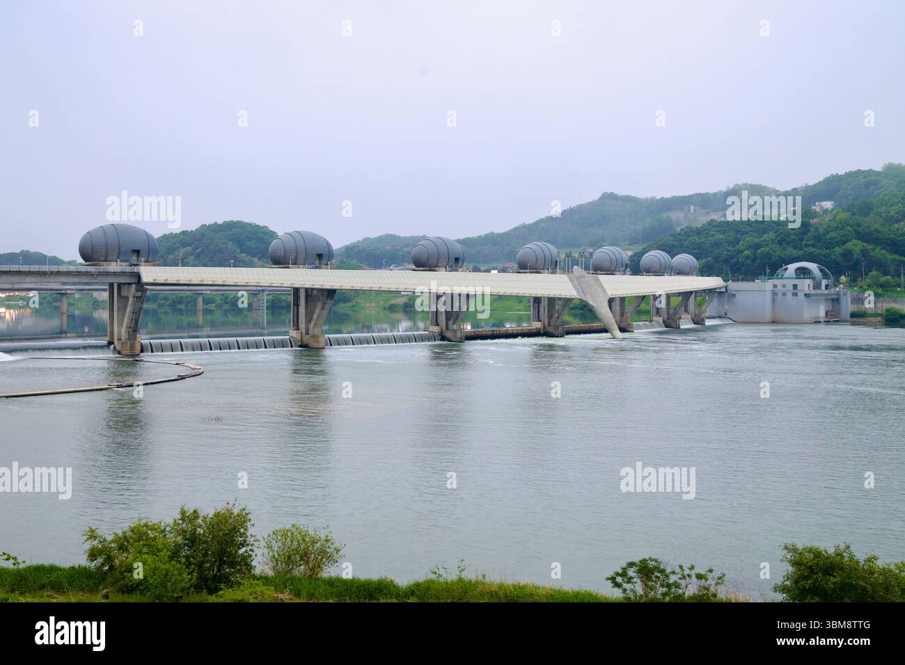 Yeoju City, South Korea - May 19th, 2025: A wide-angle look at Ipo Weir reveals its distinctive egg-shaped gate towers stretching across the South Han Stock Photo